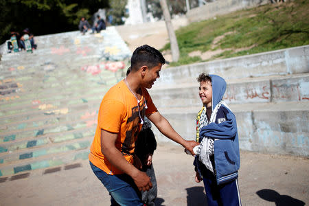 Palestinian Mustafa Sarhan, 19, a member of Gaza Skating Team plays with a boy in Gaza City March 10, 2019. REUTERS/Mohammed Salem
