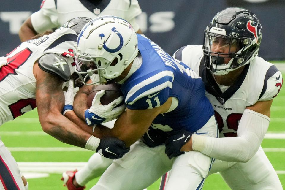 Houston Texans cornerback Derek Stingley Jr. (24) and linebacker Henry To'oTo'o (39) tackle Indianapolis Colts wide receiver Michael Pittman Jr. (11) at NRG Stadium.