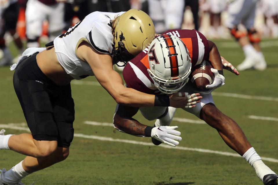 Wofford defensive back Harrison Morgan, left, tackles Virginia Tech's Jalen Holston (0) during the first half of an NCAA college football game, Saturday, Sept. 17, 2022, in Blacksburg Va. (Matt Gentry/The Roanoke Times via AP)