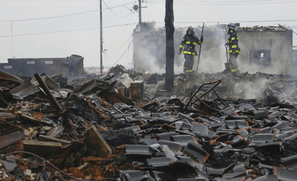 Bomberos observan los escombros y restos de un mercado calcinado por un incendio que se originó por terremotos, el miércoles 3 de enero de 2024 en Wajima, en la prefectura de Ishikawa, Japón. (Kyodo News via AP)