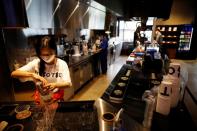 An employee wearing a mask to avoid the spread of the coronavirus disease (COVID-19) works at a cafe in Seoul