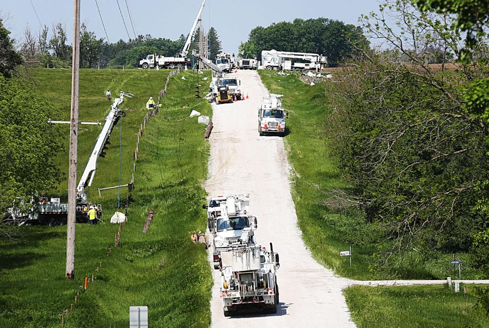 Workers from electric company work to restore power after a powerful tornado took down powerlines on 220th Street near Colo, Iowa, on Wednesday, May 22, 2024.