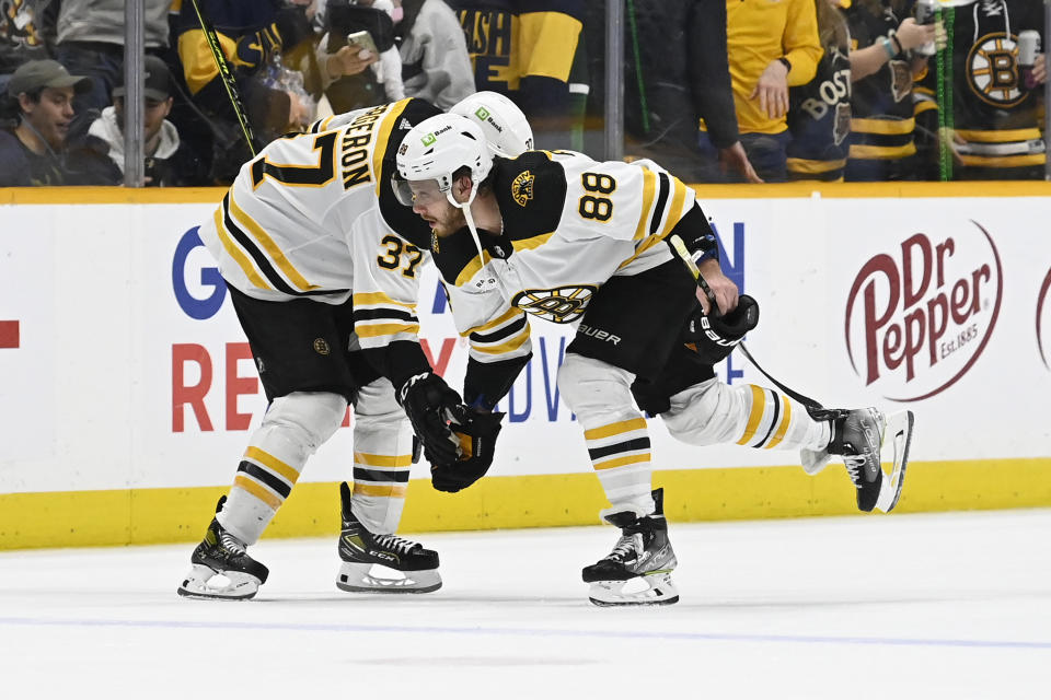 Boston Bruins center Patrice Bergeron (37) and right wing David Pastrnak (88) celebrate the team's 5-0 win over the Nashville Predators in an NHL hockey game Thursday, Feb.16, 2023, in Nashville, Tenn. (AP Photo/Mark Zaleski)