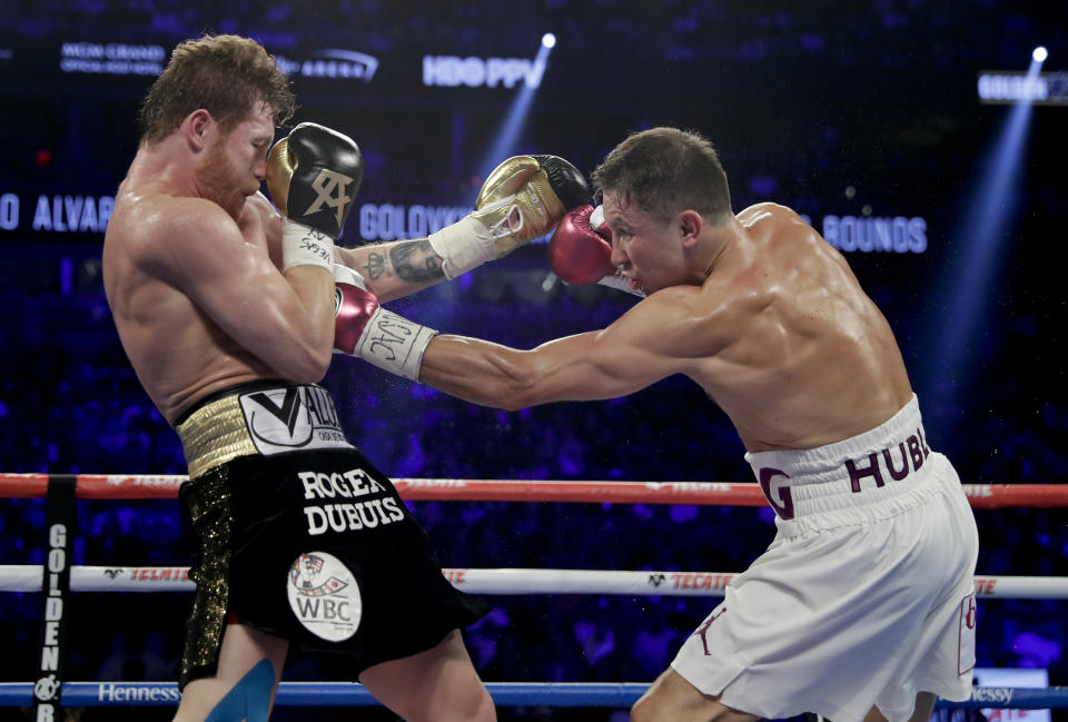 Canelo Alvarez, left, and Gennady Golovkin trade punches in the third round during a middleweight title boxing match, Saturday, Sept. 15, 2018, in Las Vegas. (AP Photo/Isaac Brekken)