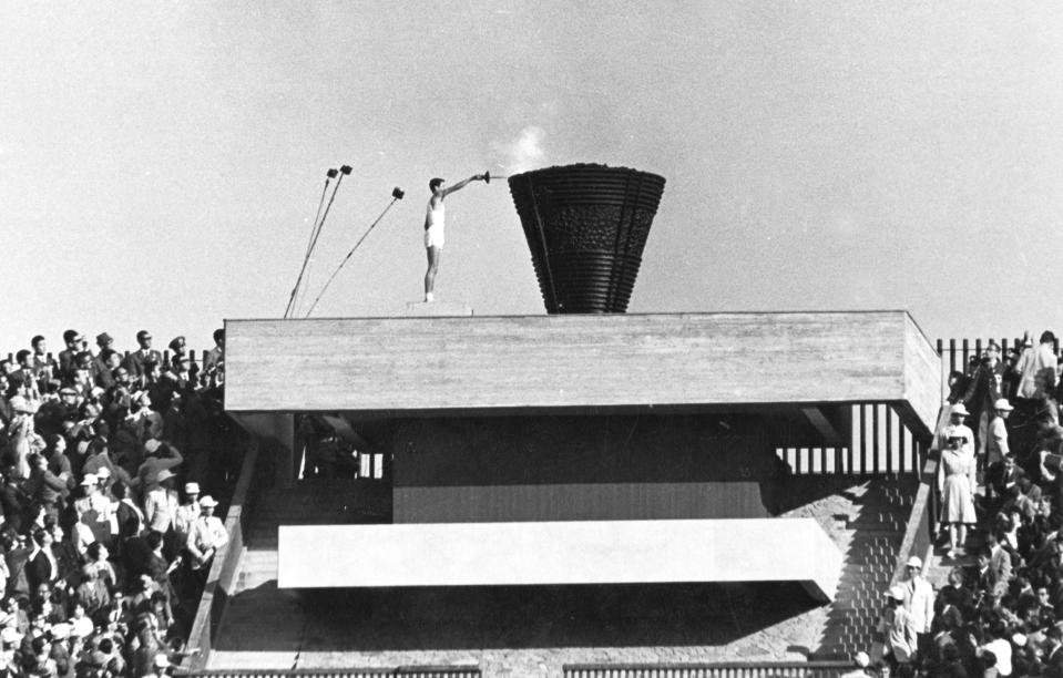 FILE - In this Oct. 10, 1964 file photo, Japanese runner Yoshinori Sakai lights the Olympic cauldron during the opening ceremony of the 1964 Summer Olympics in Tokyo. Sakai was born in Hiroshima on Aug. 6, 1945, the day the nuclear weapon destroyed that city. He symbolized the rebirth of Japan after the Second World War as he opened the 1964 Tokyo Games. Olympic organizers say the true spirit of the games is to bring humanity together to promote amity and human excellence. But an undertone of politics has been present at every Olympics for the past several decades. (AP Photo/File)