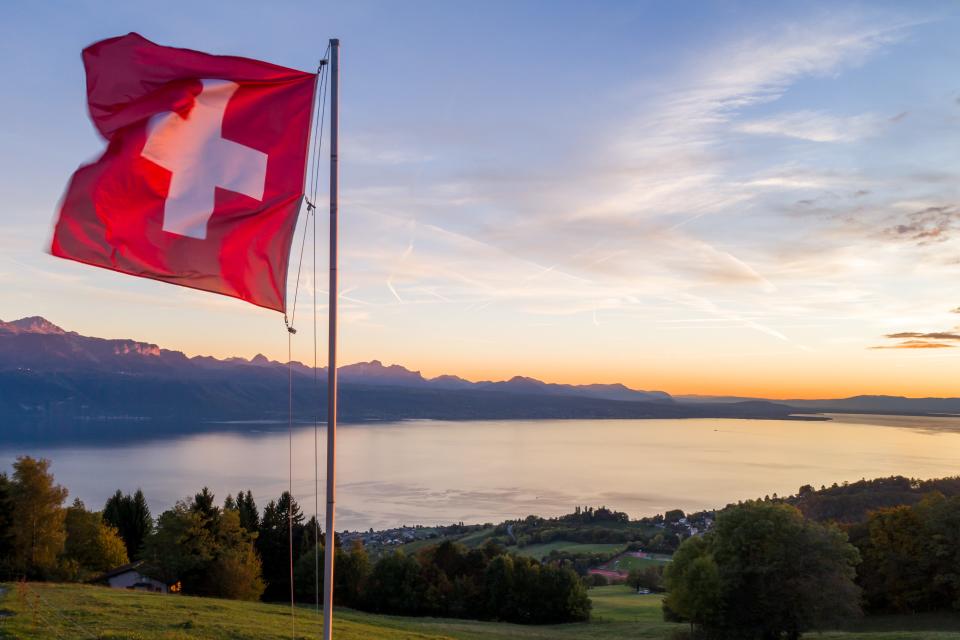 A Swiss flag is seen at sunset above Lake Geneva from Riez, France, on Oct. 5, 2017.