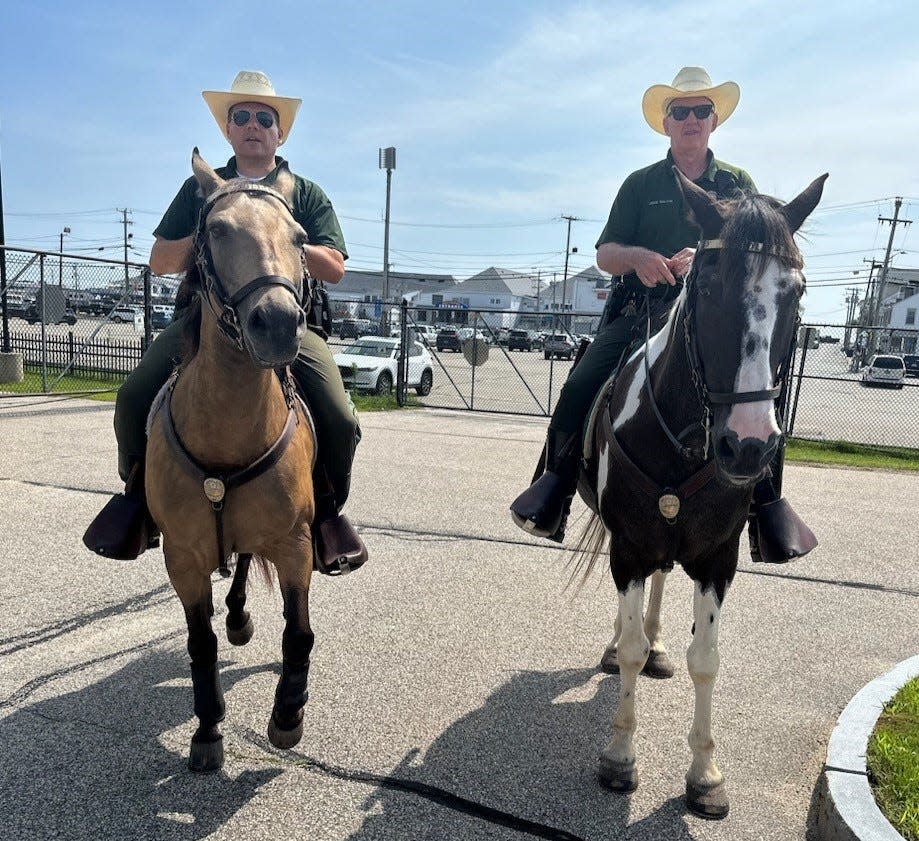 Hampton police patrolman Peter Moisakis is seen riding Tucker alongside retired Sgt John Galvin, who is on Goliath, earlier this summer at Hampton Beach.