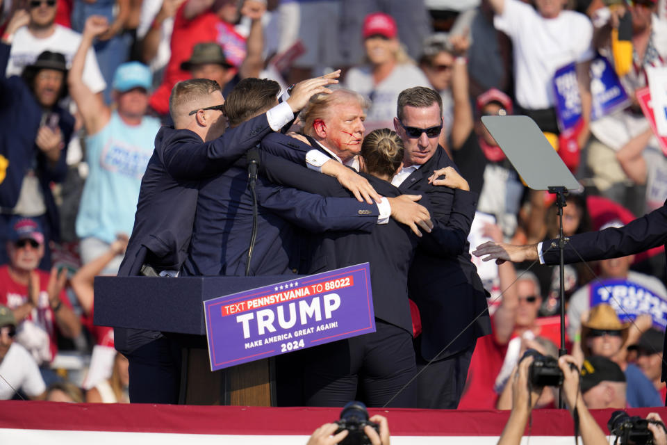 El expresidente y virtual candidato presidencial republicano Donald Trump es ayudado para bajar del estrado en un mitin de campaña en Butler, Pensilvania, el sábado 13 de julio de 2024. (AP Foto/Gene J. Puskar)