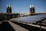 Solar panels are seen in front of a natural gas power plant at the Tahoe-Reno Industrial Center in McCarran, Nevada, September 16, 2014. REUTERS/Max Whittaker