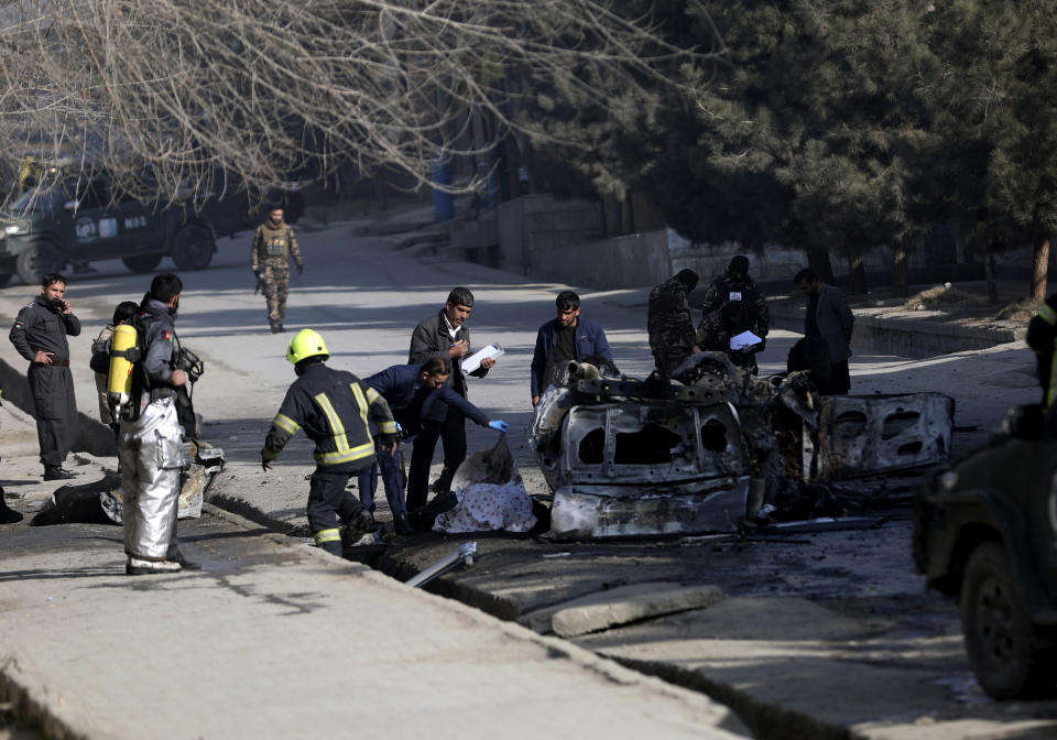 Afghan security officers inspect the site of a bombing attack in Kabul, Afghanistan, Sunday, Jan. 10, 2021. A roadside bomb exploded in Afghanistan's capital Sunday, killing at least a few people in a vehicle, the latest attack to take place even as government negotiators are in Qatar to resume peace talks with the Taliban. (AP Photo/Rahmat Gul)