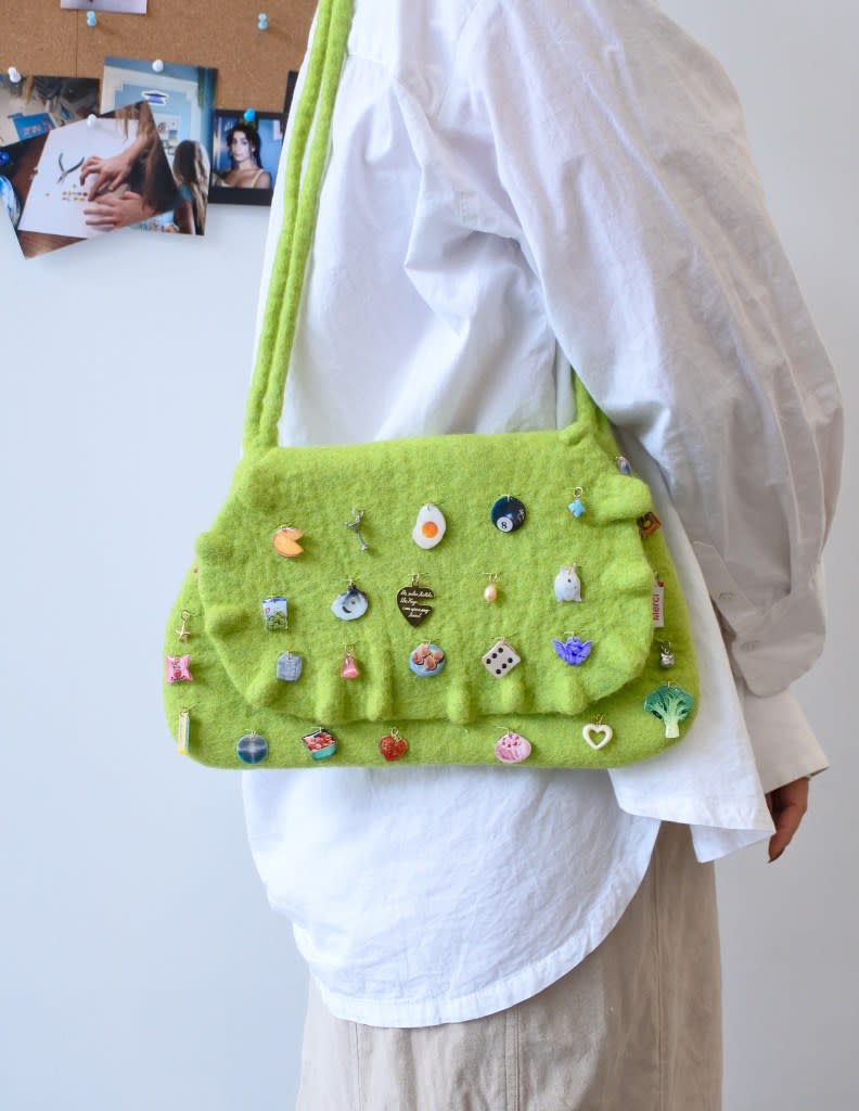 Charm enthusiasts can purchase a wool felt bag adorned with handmade embellishments from Haricot Vert. Courtesy of Haricot Vert