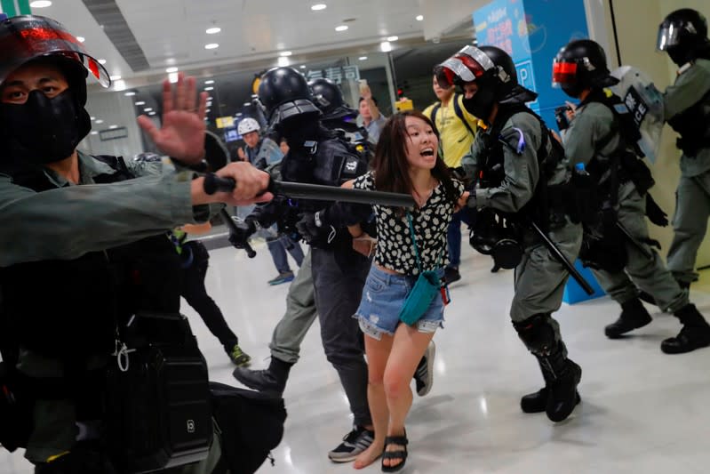 Riot police detain an anti-government protester at shopping mall in Tai Po, Hong Kong