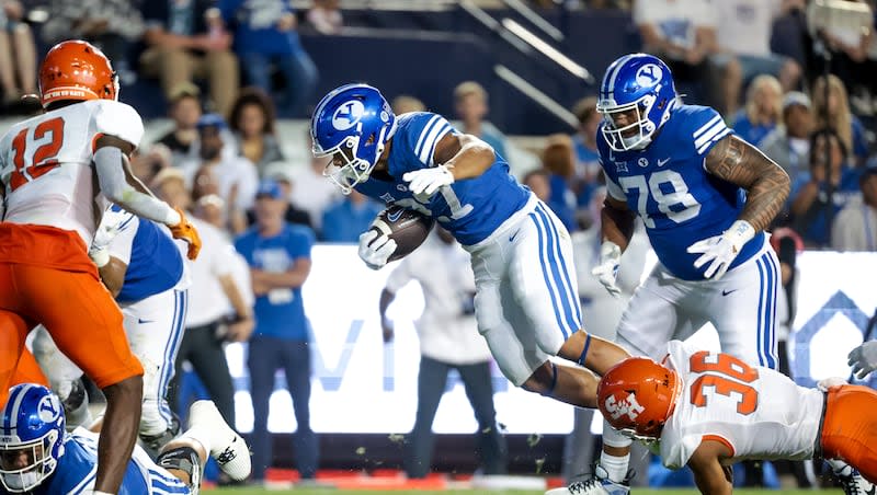 BYU Cougars running back LJ Martin (27) is tackled by Sam Houston Bearkats defensive back Elias Escobar (36) during the game at LaVell Edwards Stadium in Provo on Saturday, Sept. 2, 2023.