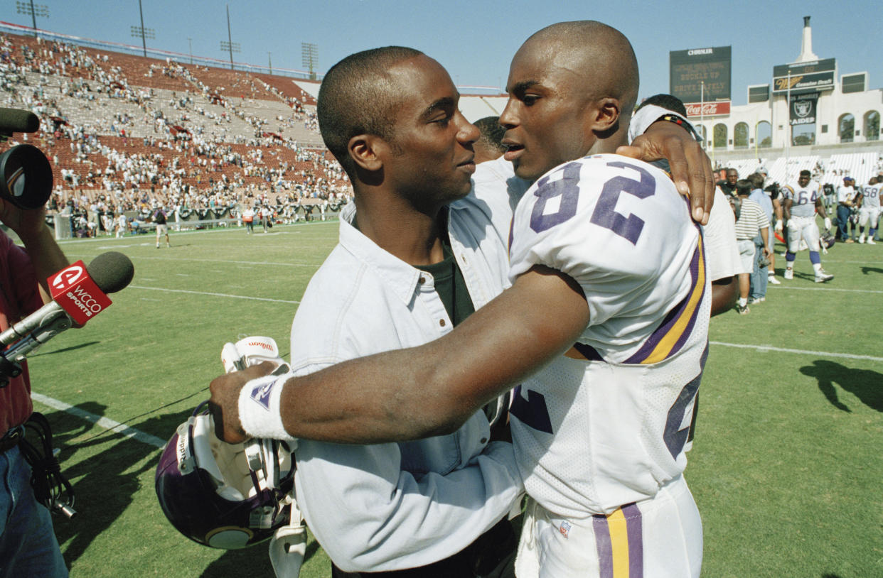 Raghib “Rocket” Ismail (L) hugs his brother, Qadry, after an NFL game. The brothers’ two schools, Notre Dame and Syracuse, play each other on Saturday. (AP)