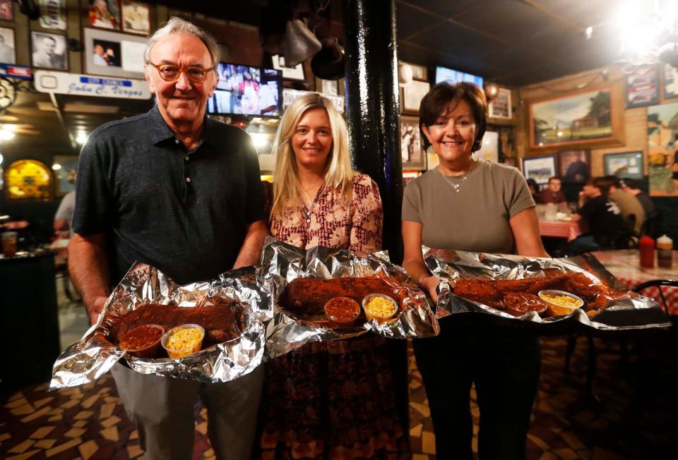 Owners John Vergos, from left, Anna Vergos Blair and Tina Vergos Jennings hold plates of ribs inside The Rendezvous in Downtown Memphis on Sept. 26, 2023. The charbroiled ribs at The Rendezvous are world-famous. "The 'Vous" documentary dives into the legendary spot's history.