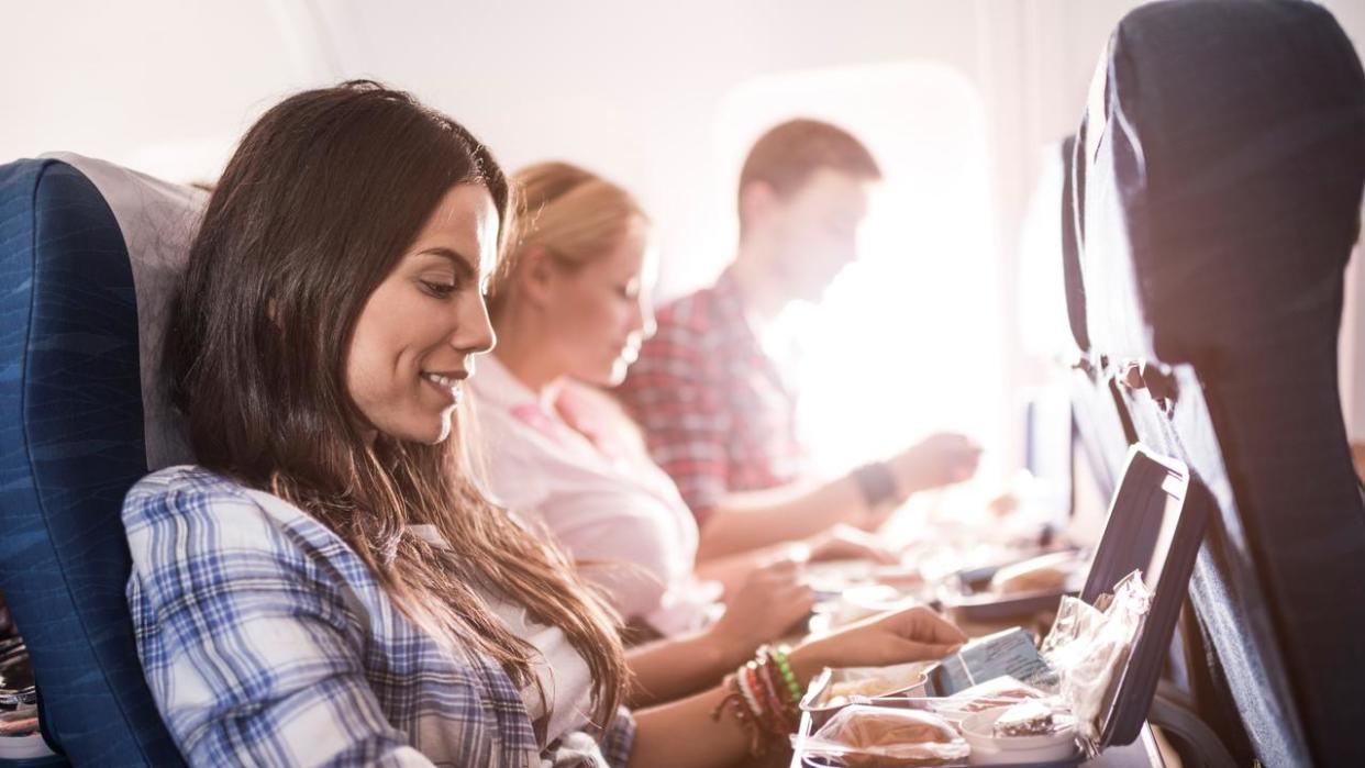 Passengers having lunch while traveling by airplane.