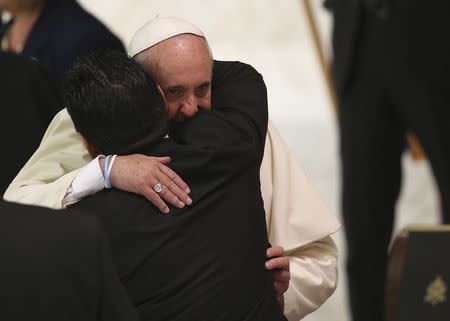 Former soccer star Diego Maradona (L) hugs Pope Francis during a special audience held before a special interreligious "Match for Peace", at the Paul VI hall at the Vatican September 1, 2014. REUTERS/Alessandro Bianchi