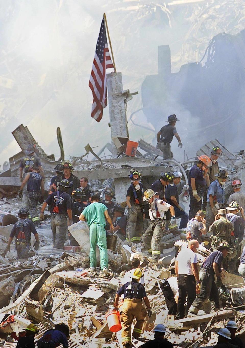 An American flag is posted in the rubble of the World Trade Centre as firemen and rescue workers clear the debris (EPA)