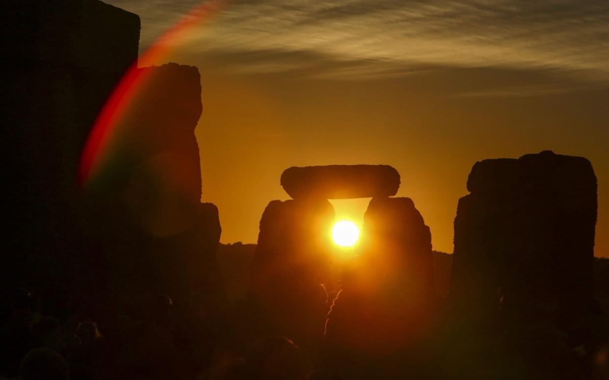 The sun rises during the Summer Solstice at Stonehenge in Wiltshire, last year - AFP