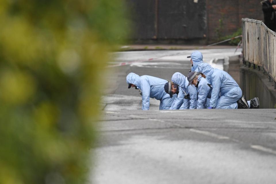 Police forensic officers search a street in the wake of the shooting (Kirsty O’Connor/PA) (PA Archive)