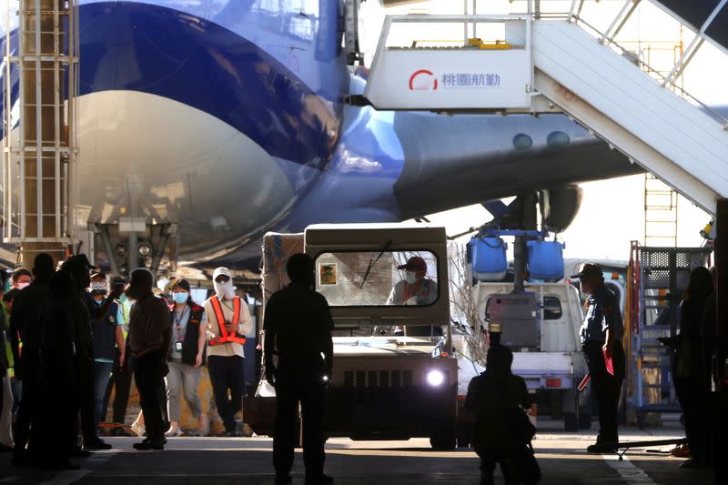 Workers transport Moderna vaccines against the coronavirus disease (COVID-19) to Taiwan Air cargo Terminal in Taoyuan