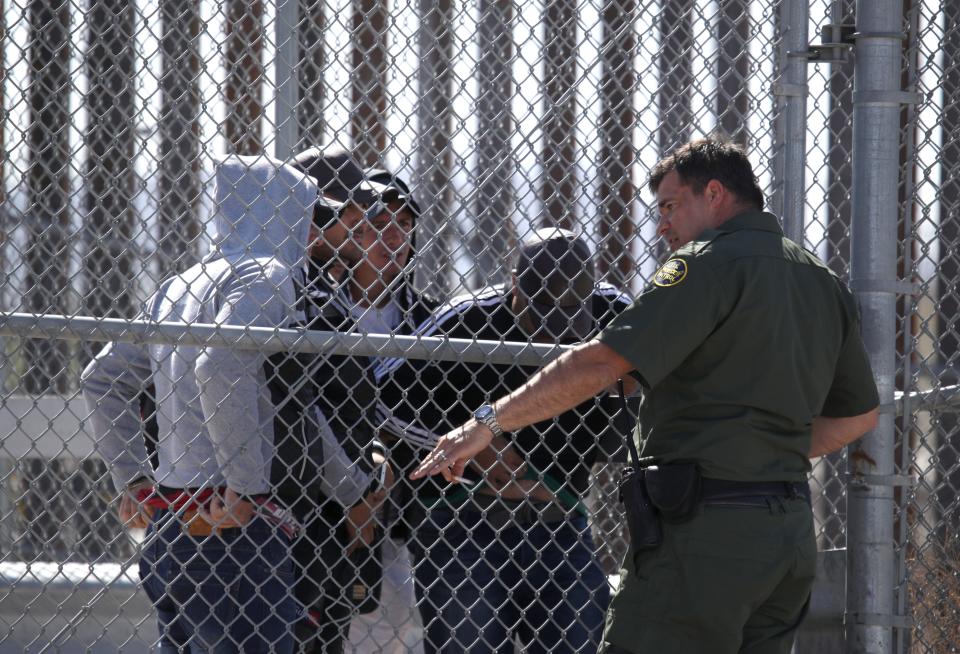 A U.S. Border Patrol agent talks with detained migrants at the border of the United States and Mexico on March 31, 2019 in El Paso, Texas. U.S. President Donald Trump has threatened to close the United States border if Mexico does not stem the flow of illegal migrants trying to cross. (Photo by Justin Sullivan/Getty Images)