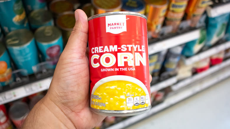 Man holding Market Pantry canned corn