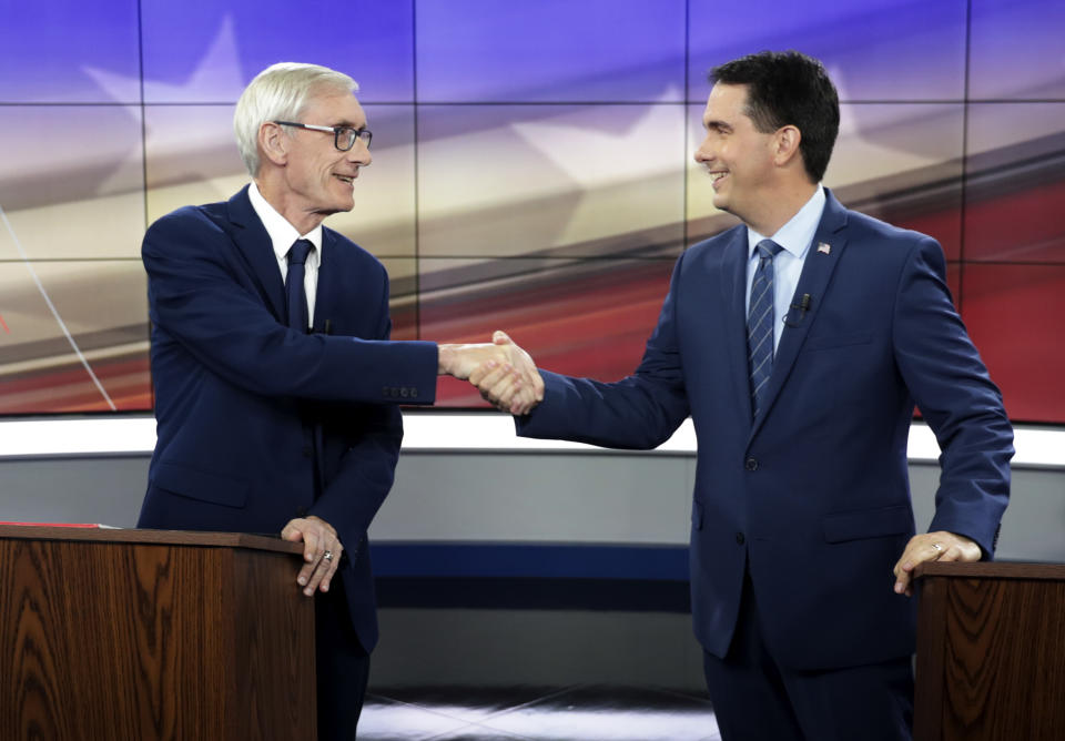 Democratic Challenger Tony Evers, left, and Gov. Scott Walker, a Republican, during a 10-minute media event before the start of their gubernatorial debate hosted by the Wisconsin Broadcasters Association Foundation in Madison, Wis., Friday, Oct. 19, 2018. (Steve Apps/Wisconsin State Journal via AP)