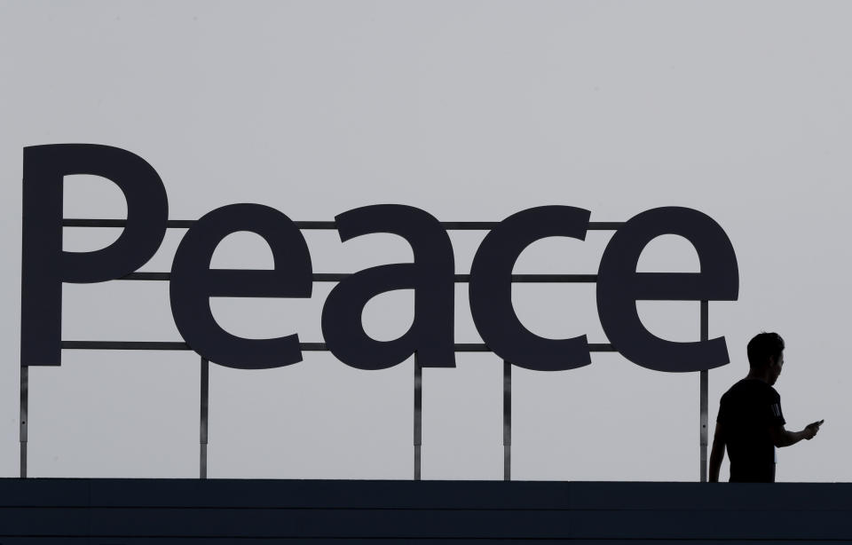 In this Wednesday, Aug. 15, 2018, photo, a man walks by a "Peace" sign before a ceremony to celebrate Korean Liberation Day in Seoul, South Korea. (AP Photo/Lee Jin-man, File)