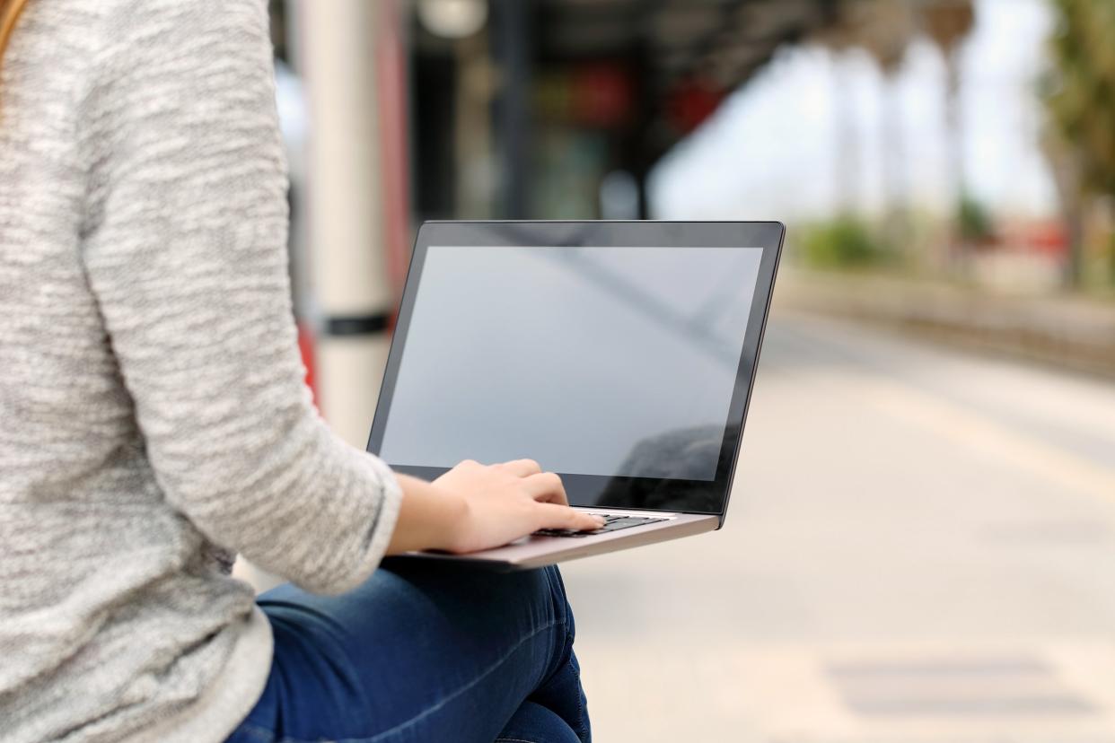 Person sitting outside using a laptop