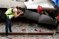 <p>A railway technician photographs damage at a train wagon at the Estacio de Franca (Franca station) in central Barcelona on July 28, 2017 after a regional train appears to have hit the end of the track inside the station injuring dozens of people. (Photo: Miquel Llop/NurPhoto via Getty Images) </p>