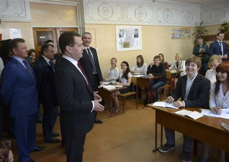 Russia's Prime Minister Dmitry Medvedev (C, front) visits an upper secondary school in the Crimean city of Simferopol, March 31, 2014. REUTERS/RIA Novosti/Alexander Astafyev/Pool