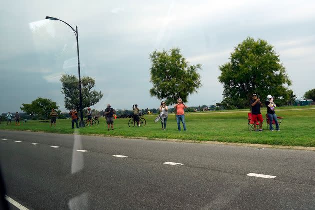 Observers watch along George Washington Memorial Parkway as the motorcade carrying Trump departs from Ronald Reagan Washington National Airport.