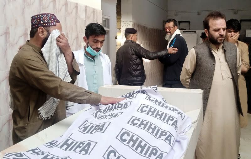 Man mourns the death of a relative as other gather at hospital morgue after a blast in Quetta