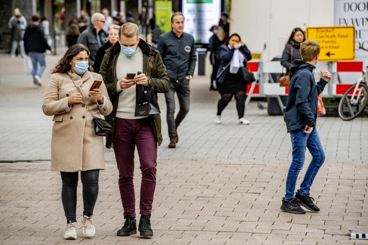People wearing face masks as a preventive measure walk on (Robin Utrecht / LightRocket via Getty Images file)