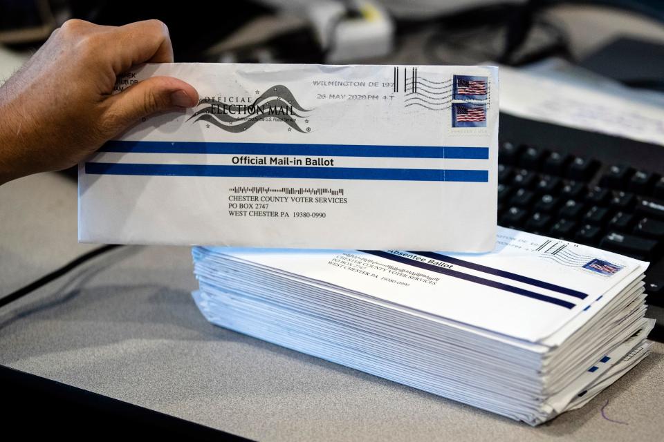 In this May 28, 2020, file photo, mail-in primary election ballots are processed at the Chester County Voter Services office in West Chester, Pa. Pennsylvania officials said Friday, July 31, 2020, the state will foot the cost of postage for voters to mail-in ballots in November's general election, a move that Gov. Tom Wolf has made a priority as the coronavirus pandemic unexpectedly fueled high interest in voting by mail under new state law.