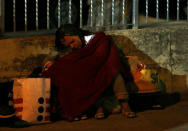 A woman sleeps covered with a blanket as she spends the night in the open following an earthquake in Amatrice, central Italy, August 24, 2016. REUTERS/Stefano Rellandini