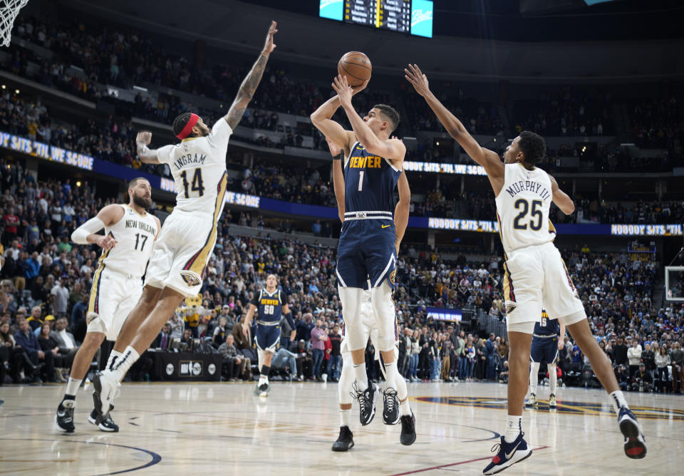 Denver Nuggets forward Michael Porter Jr., center, drives to the rim between New Orleans Pelicans forward Brandon Ingram, left, and guard Trey Murphy III in the first half of an NBA basketball game Tuesday, Jan. 31, 2023, in Denver. (AP Photo/David Zalubowski)