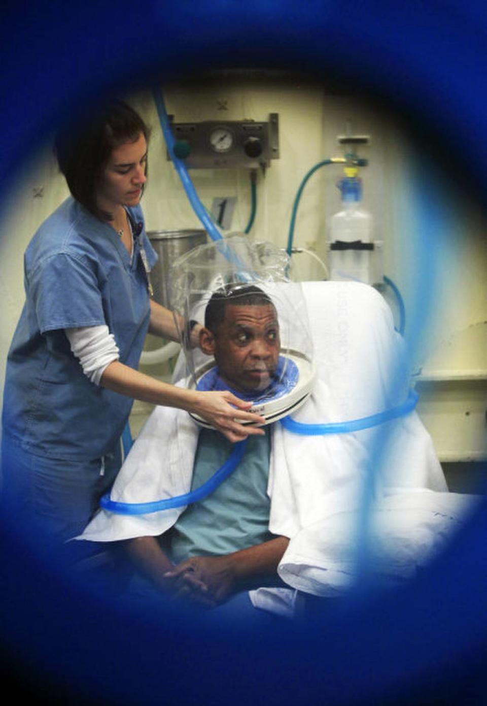 A file photo shows a patient at Duke University Hospital being prepared hyperbaric oxygen chamber treatment.