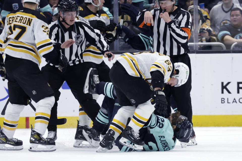 Boston Bruins left wing Brad Marchand (63) and Seattle Kraken right wing Oliver Bjorkstrand (22) fight during the third period of an NHL hockey game Thursday, Feb. 23, 2023, in Seattle. The Bruins won 6-5. (AP Photo/John Froschauer)