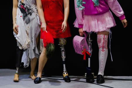 Women wearing prosthetic legs participate in a public photo session at the Hasselblad and Profoto booth, during the CP+ camera and imaging equipment trade fair in Yokohama south of Tokyo, February 14, 2015. REUTERS/Thomas Peter