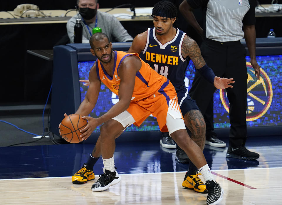 Phoenix Suns guard Chris Paul, left, pulls in a loose ball as Denver Nuggets guard Gary Harris defends during the second half of an NBA basketball game Friday, Jan. 1, 2021, in Denver. The Suns won 106-103. (AP Photo/David Zalubowski)