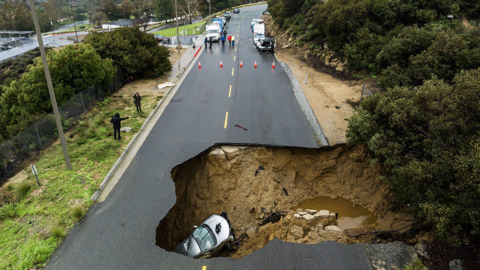A large sinkhole opened up on a road in the Chatsworth area of Los Angeles in January, swallowing two vehicles, after torrential rain inundated the area. - Ted Soqui/Sipa/AP
