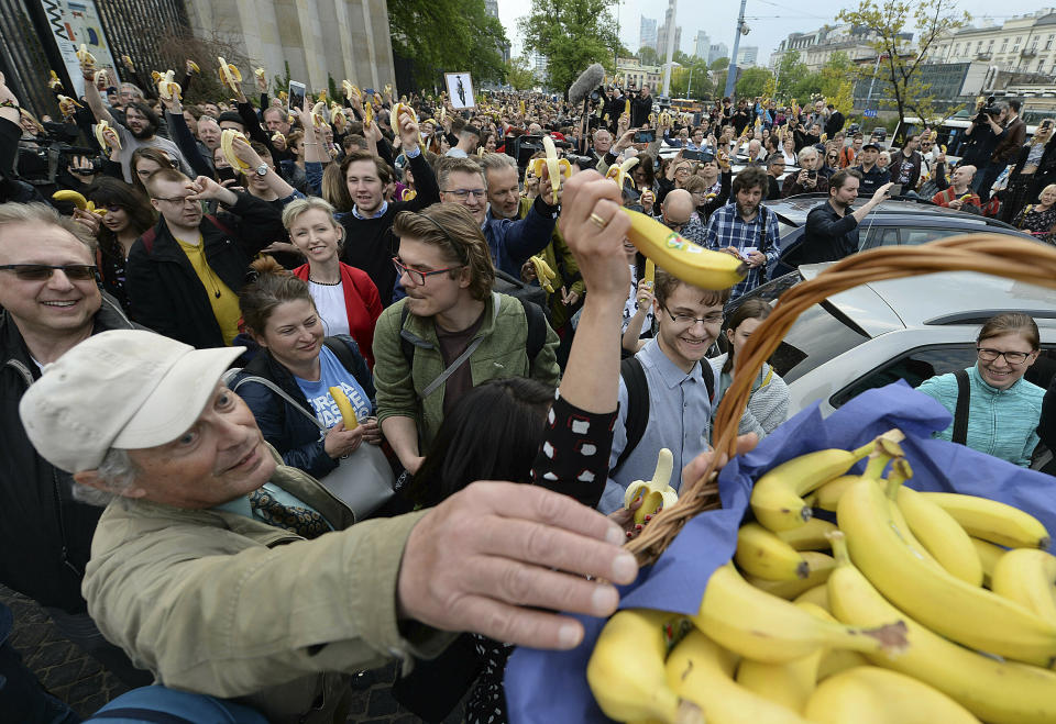 People with bananas demonstrate outside Warsaw's National Museum, Poland, Monday, April 29, 2019, to protest against what they call censorship, after authorities removed an artwork at the museum featuring the fruit, saying it was improper. (AP Photo/Czarek Sokolowski)