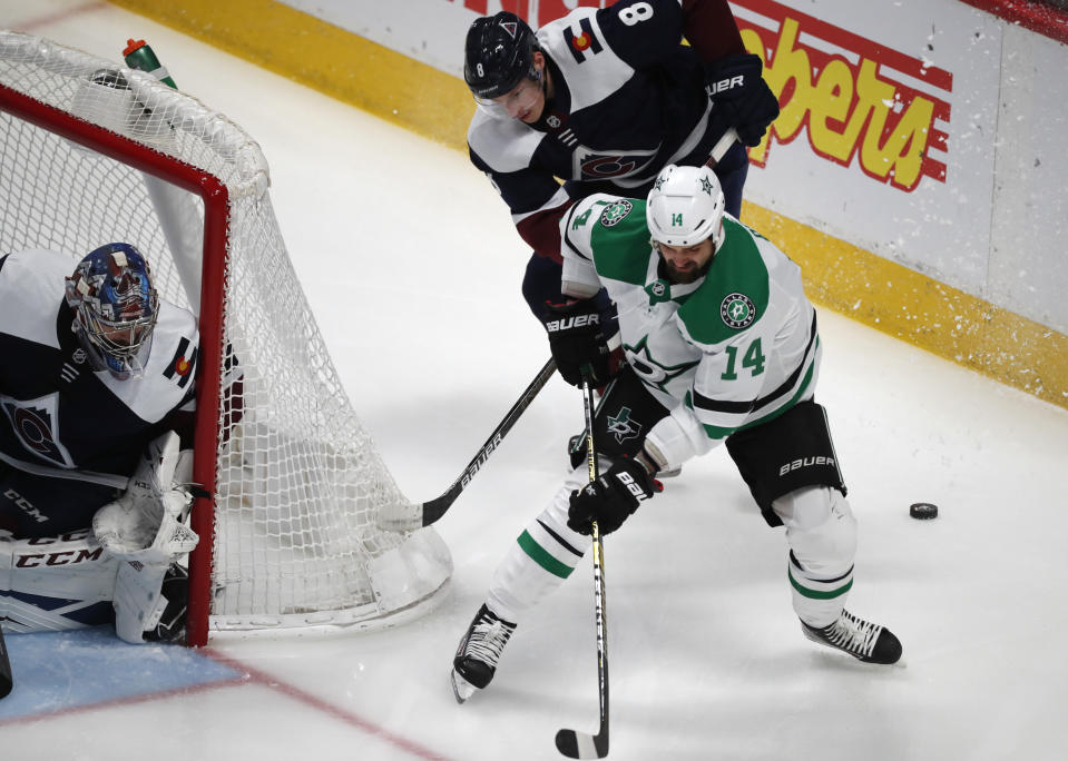 Dallas Stars left wing Jamie Benn, front right, loses control of the puck as Colorado Avalanche defenseman Cale Makar, back right, and goaltender Philipp Grubauer cover in the first period of an NHL hockey game Tuesday, Jan. 14, 2020, in Denver. (AP Photo/David Zalubowski)