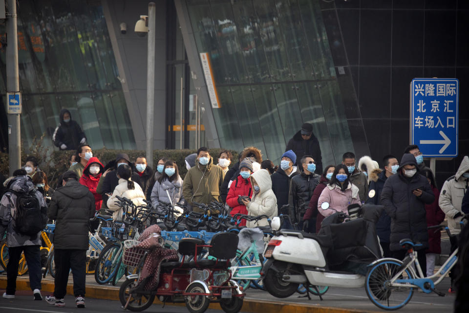 People wearing face masks to protect against the spread of the coronavirus line up for mass COVID-19 testing in a central district of Beijing, Friday, Jan. 22, 2021. Beijing has ordered fresh rounds of coronavirus testing for about 2 million people in the downtown area following new cases in the Chinese capital. (AP Photo/Mark Schiefelbein)