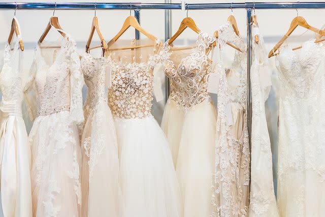 <p>Getty</p> Stock image of wedding dresses hanging on a rack in a store