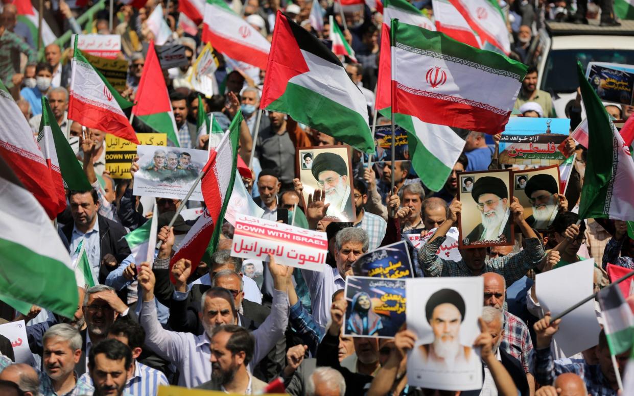 People march with flags and banners to celebrate Iran's April 13 attack on Israel and protest Israel