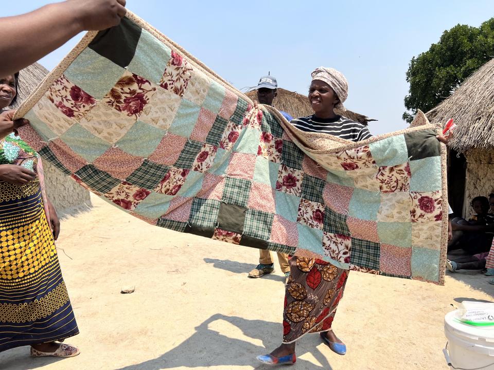 Mujawayesu Emelita displays her MCC comforter at Meheba Refugee Settlement Camp in Zambia.