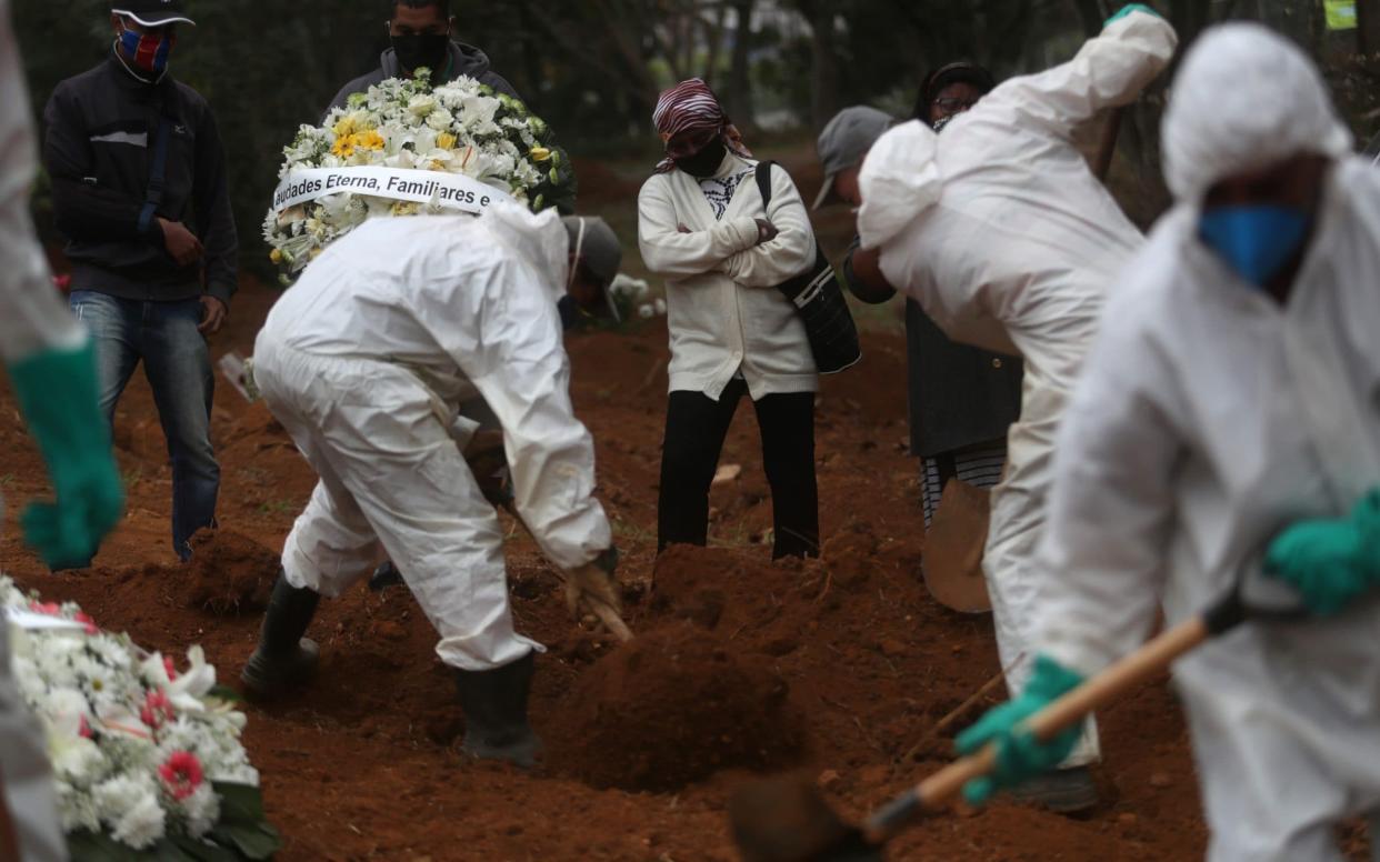 Gravediggers bury a man who died from Covid-19 at Sao Luiz cemetery, in Sao Paulo, Brazil -  AMANDA PEROBELLI/Reuters